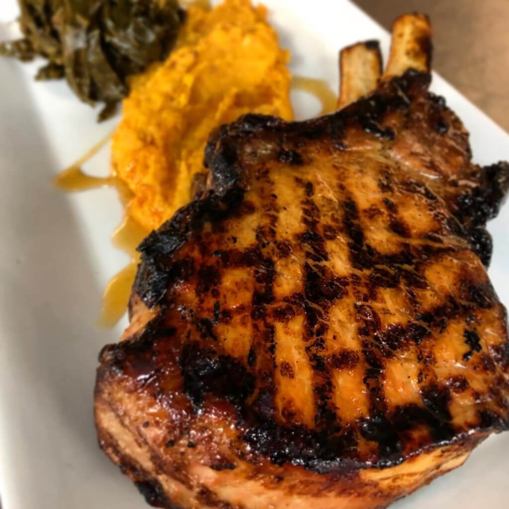 Local glazed grilled pork chop with mashed sweet potatoes and braised collard greens-onlypawleys